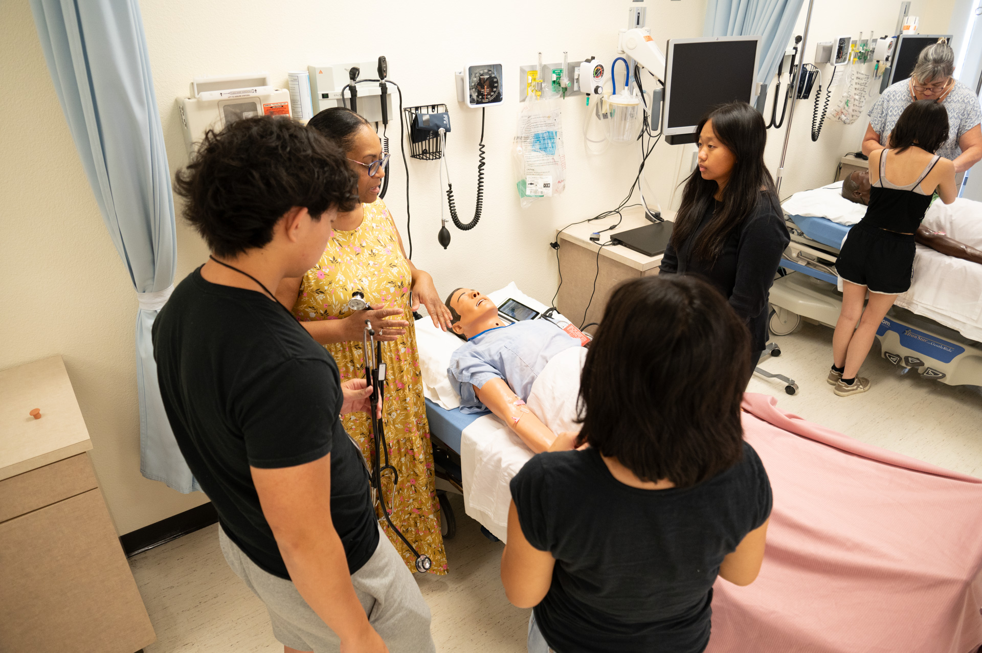 Youths and faculty learn to take vital signs on mannequins.